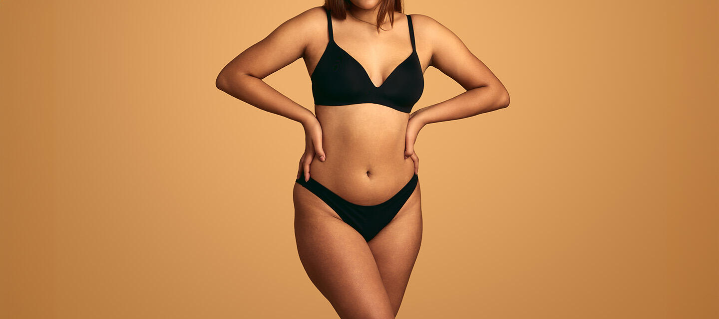 Beautiful curvy woman's body in black underwear, arms on hips